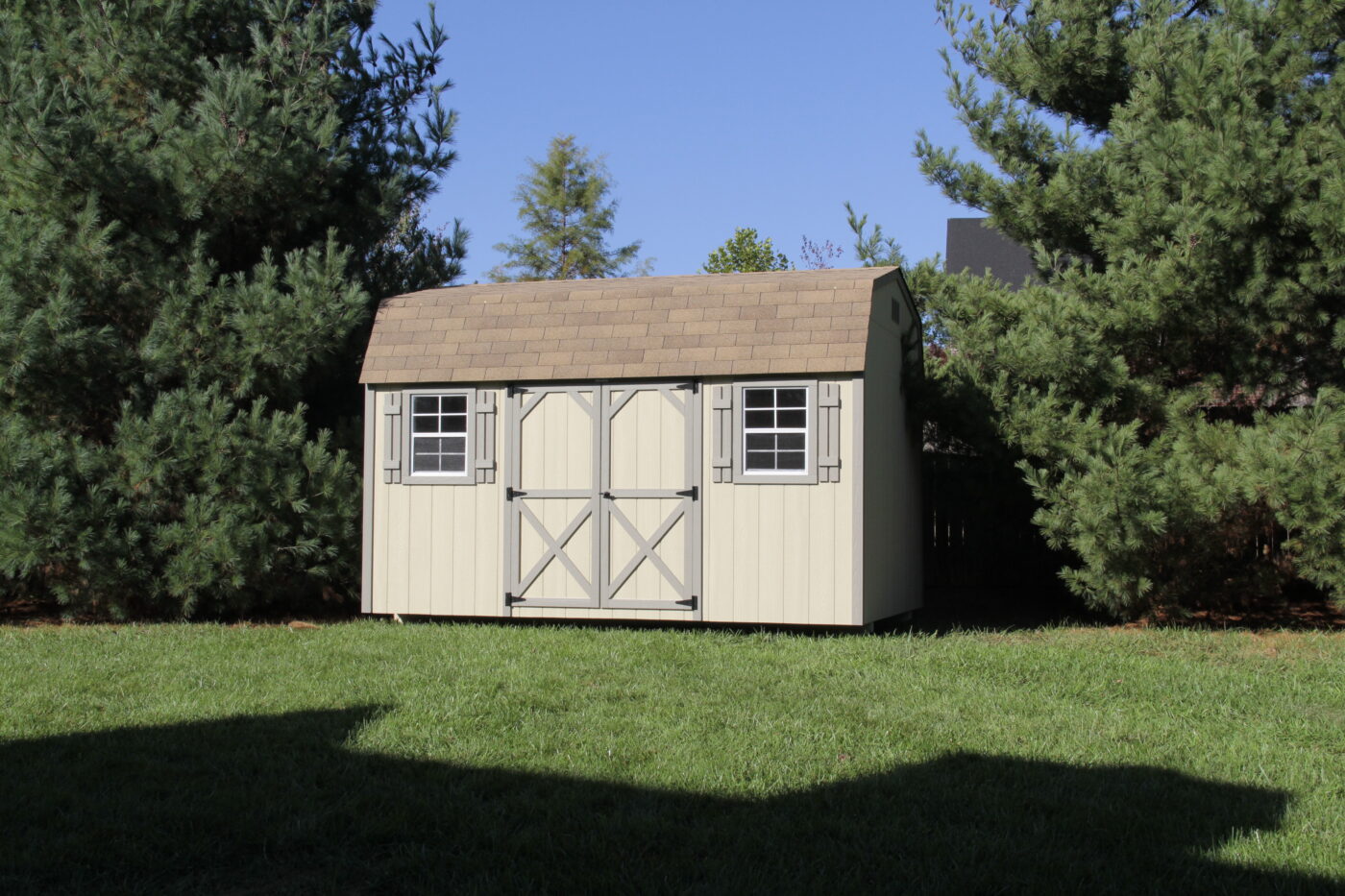 tan Deluxe barn shed in nashville, TN with gray trim double doors and a reddish shingle roof