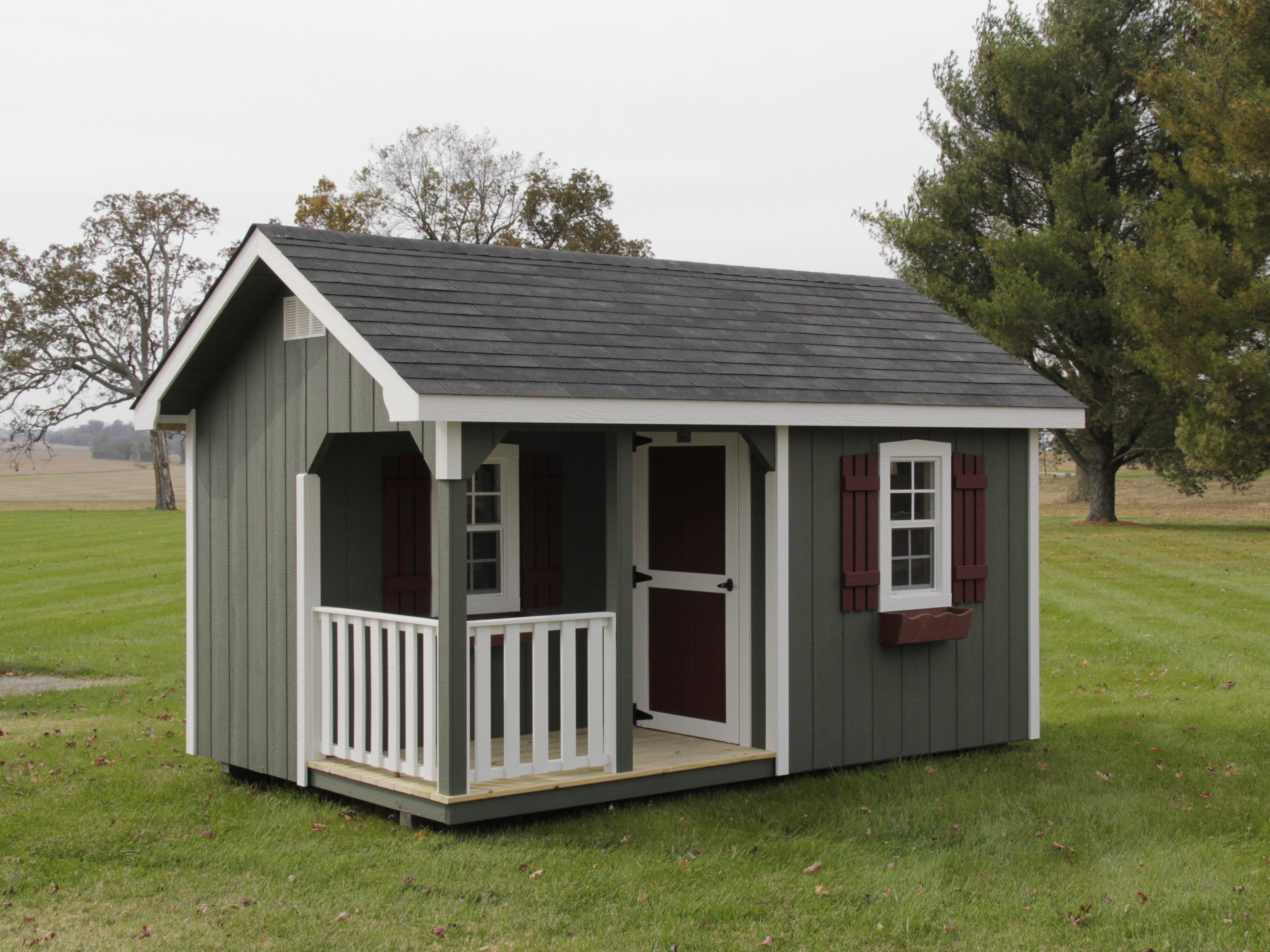 gray and white trimmed Playhouses in nashville TN for sale with windows with red shutters and flower boxes and a front porch