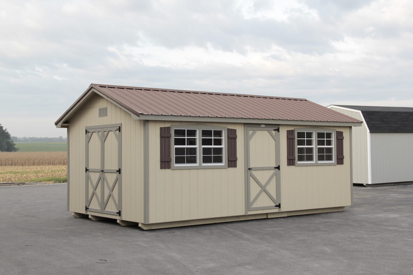 tan and light gray trimmed shed with red roof